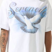 White t-shirt with a dove graphic and 'Serenade' text worn by a person.