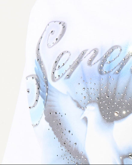 Close-up of a white garment with decorative text and embellishments on a light background