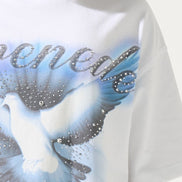 White t-shirt with a graphic design of doves and text on a plain background