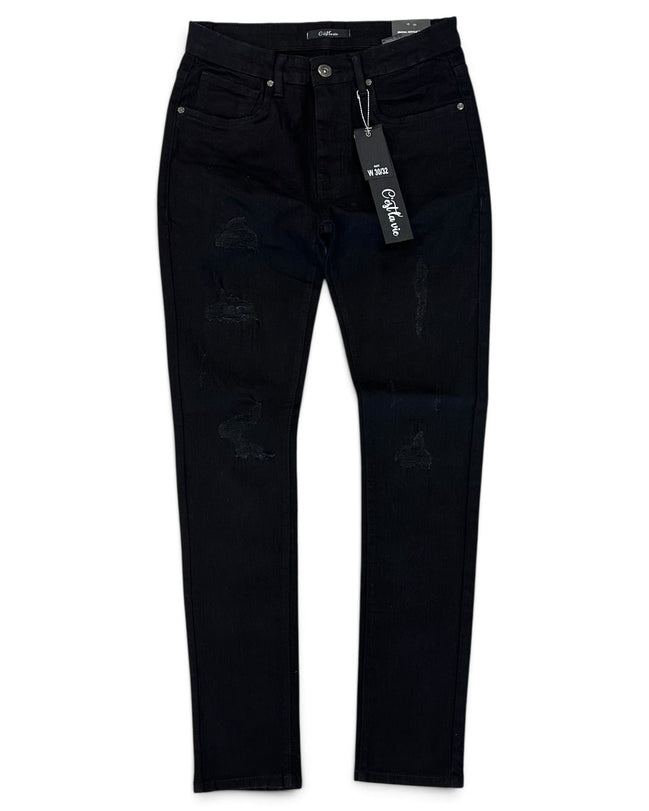 Black distressed skinny jeans with ripped details on the thighs and knees, shown flat against a white background with a hangtag attached.