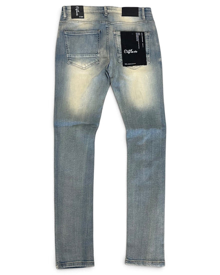 Back view of light blue denim jeans with a faded wash, featuring black brand patches on the back pockets and waistband.