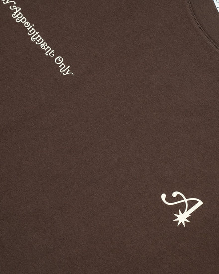 Brown t-shirt with white text and logo on a brown background