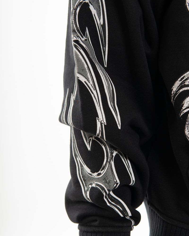 Black sweatshirt with white tribal designs on sleeves against a white background