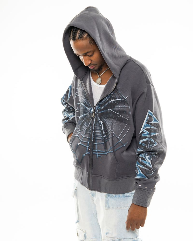 Person wearing a gray hoodie with blue designs on a white background