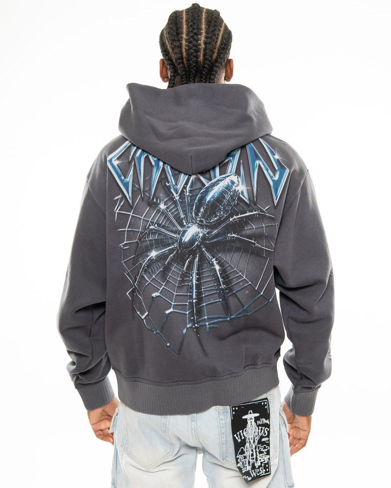 Person wearing a gray hoodie with a spider web design on the back, standing against a white background.