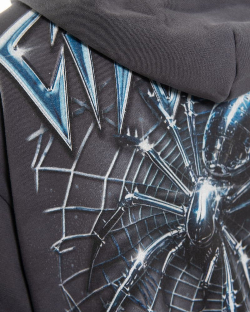 Close-up of a hoodie with a spider web and logo design.