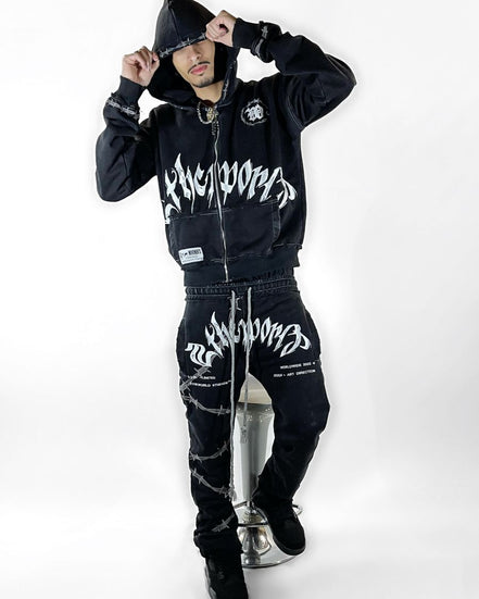 Person wearing a black hoodie and pants with white text on a white background