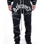 Black pants with white designs worn by a person on a white background