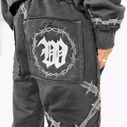Black pants with barbed wire design and logo on a white background