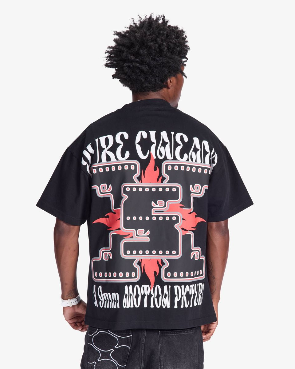 Person wearing a black t-shirt with white and red graphics on the back, on a white background