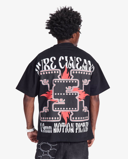 Person wearing a black t-shirt with white and red graphics on the back, on a white background