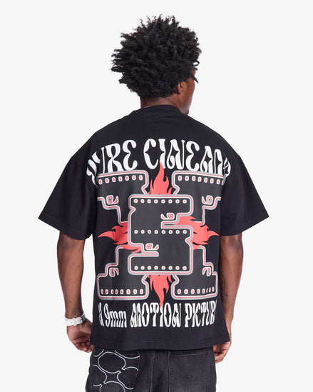 Person wearing a black t-shirt with white and red graphics on the back, on a white background