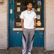 Man standing in front of a building with a blue tiled wall and glass door.