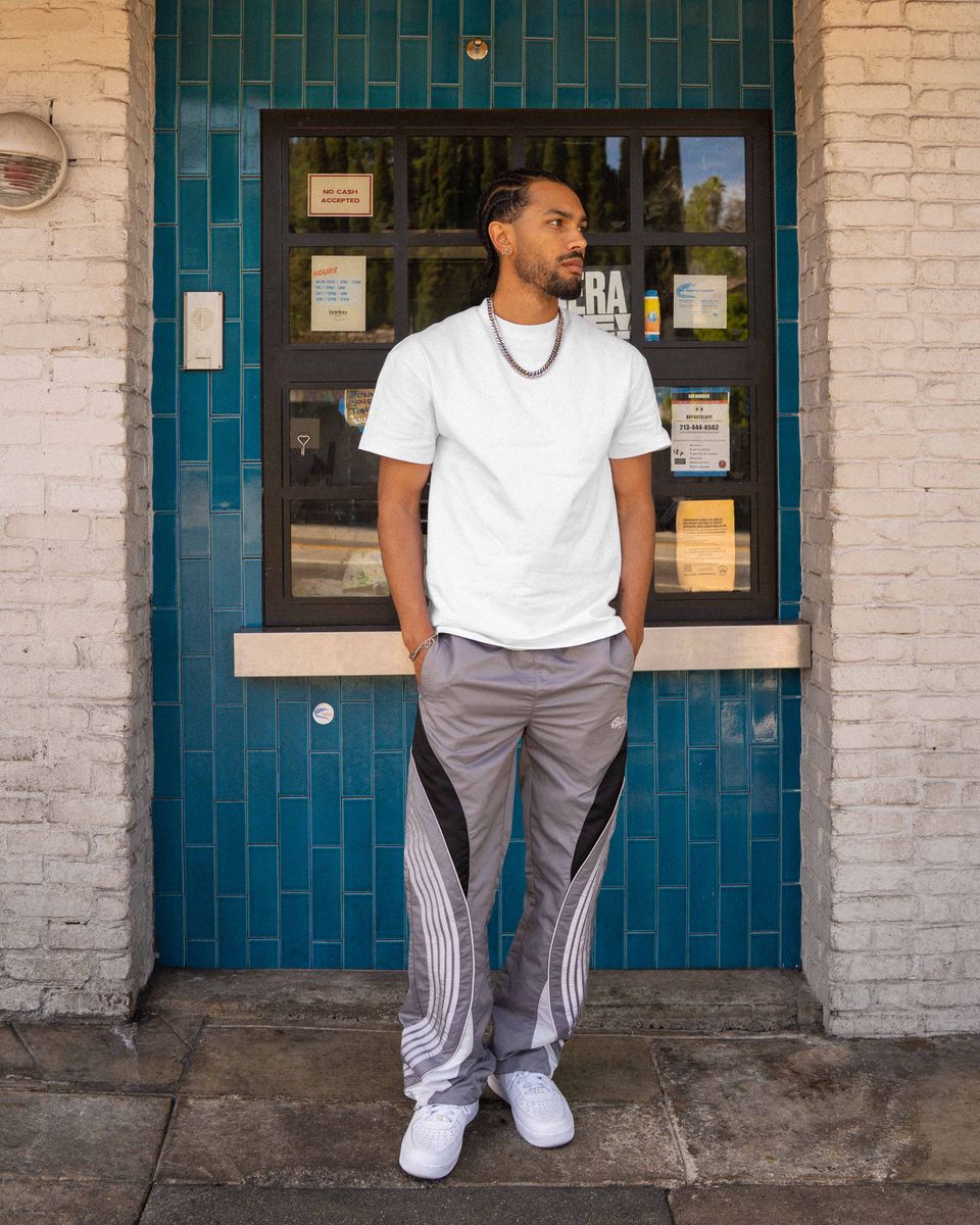 Man standing in front of a building with a blue tiled wall and glass door.