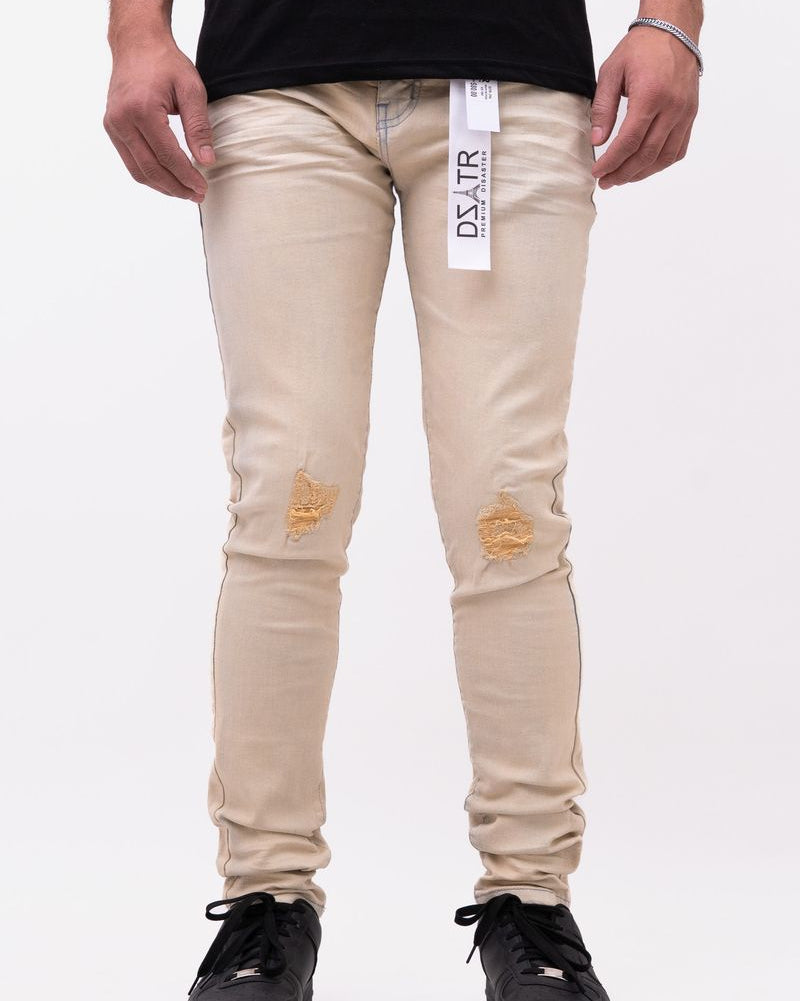 Beige distressed jeans worn by a person on a white background