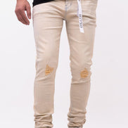 Beige distressed jeans worn by a person on a white background