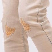 Beige jeans with patches on a white background