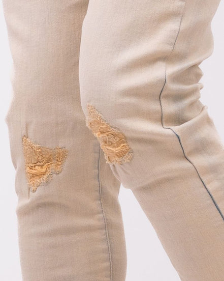 Beige jeans with patches on a white background