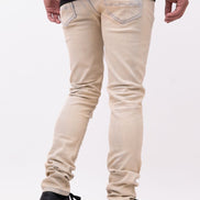 Person wearing beige jeans and black shoes on a white background