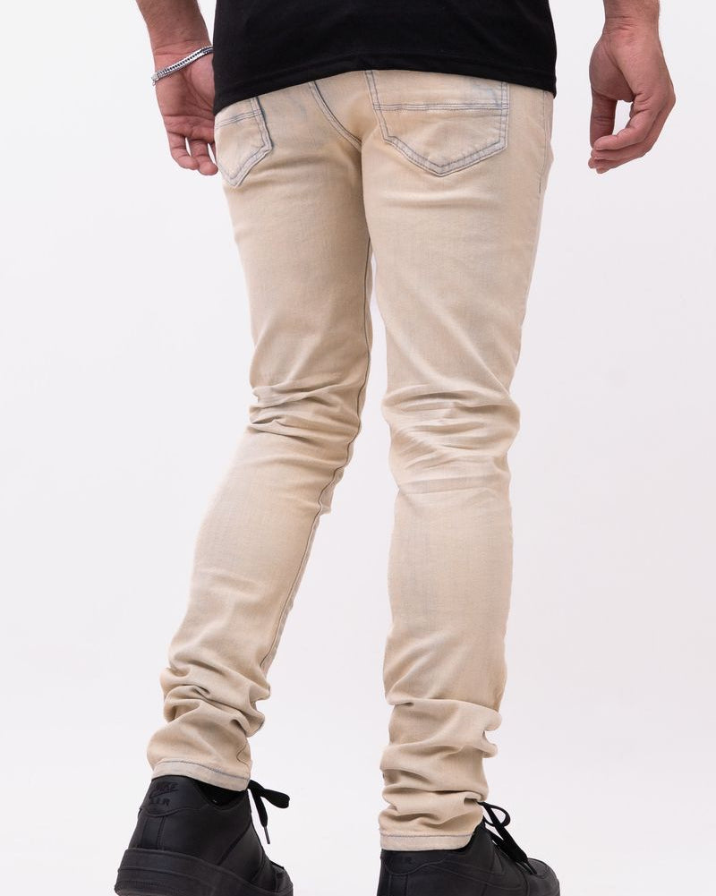 Person wearing beige jeans and black shoes on a white background
