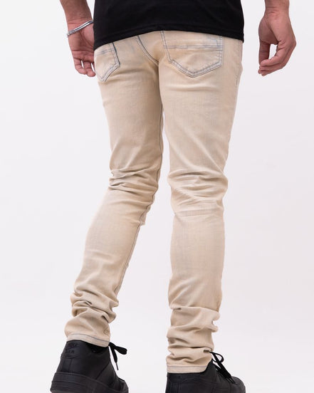 Person wearing beige jeans and black shoes on a white background