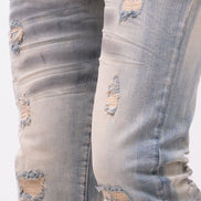 Ripped light blue jeans with a brand tag on a white background