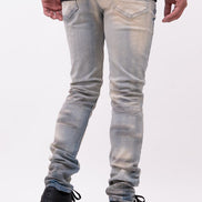 Person wearing light blue jeans and black shoes on a white background
