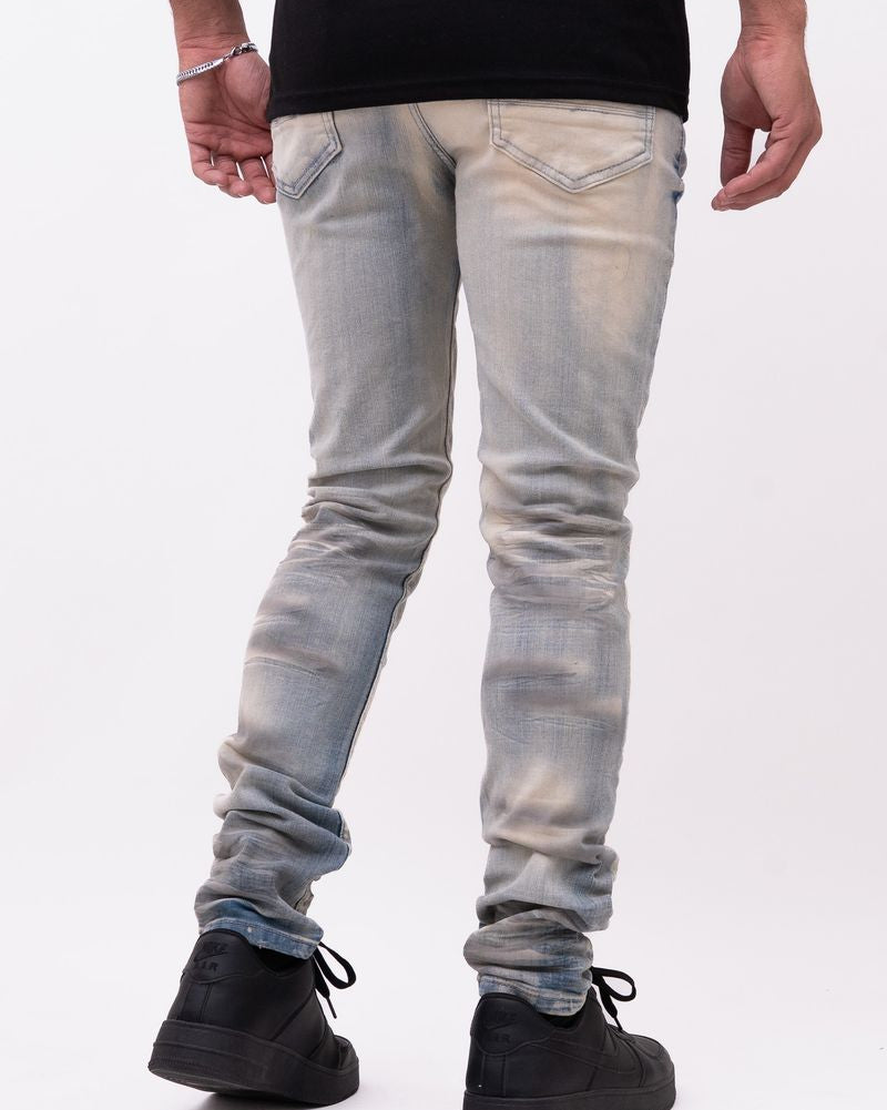 Person wearing light blue jeans and black shoes on a white background