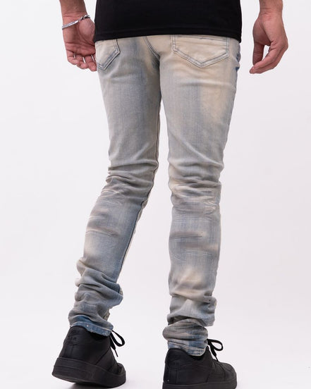 Person wearing light blue jeans and black shoes on a white background