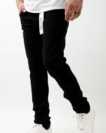 Person wearing black pants with a white brand logo on a white background