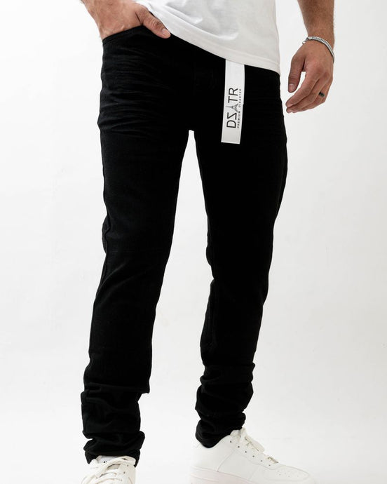 Person wearing black jogger pants with a visible brand logo on a white background