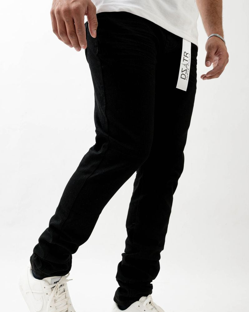 Person wearing black jogger pants with a brand logo on a white background