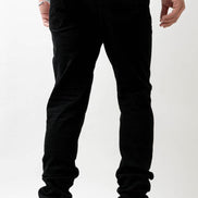 Person wearing black pants and white sneakers on a white background
