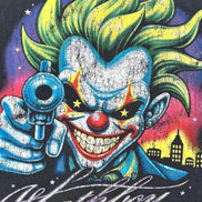 A close-up graphic print featuring a stylized clown with bright green hair, a red nose, and a blue suit holding a revolver, with the word 'Whathavey' in white script across the bottom.