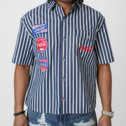 Person wearing a blue and white striped shirt with Coca-Cola logos on a white background
