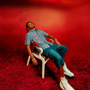 Person sitting on a chair against a red background