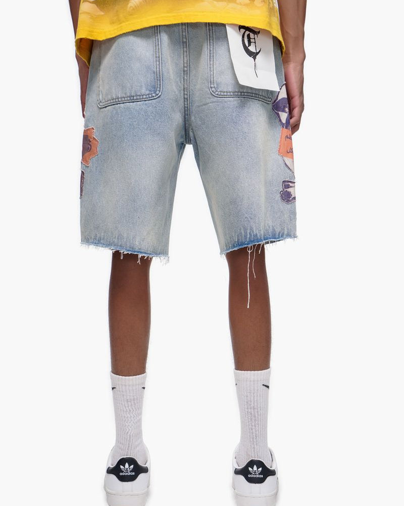 Person wearing light blue denim shorts with colorful patches on a white background
