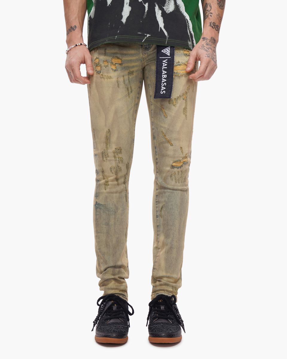 Distressed beige jeans with a brand label on a white background