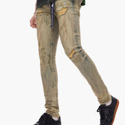 Person wearing distressed beige jeans with a visible brand label on a white background