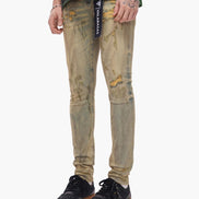 Person wearing distressed beige jeans with a visible brand label on a white background