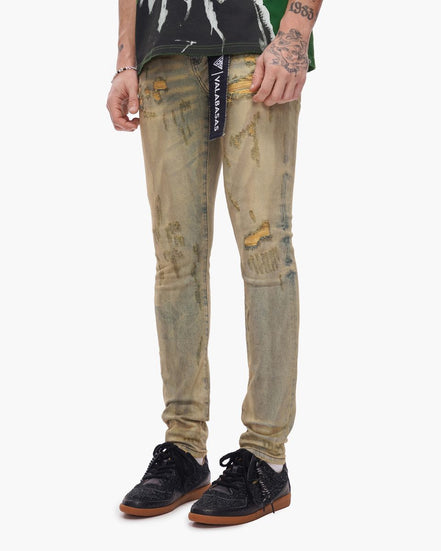 Person wearing distressed beige jeans with a visible brand label on a white background