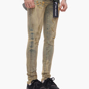 Person wearing distressed beige jeans with a brand label on a white background