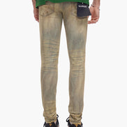 Person wearing beige distressed jeans with a visible brand logo on a white background