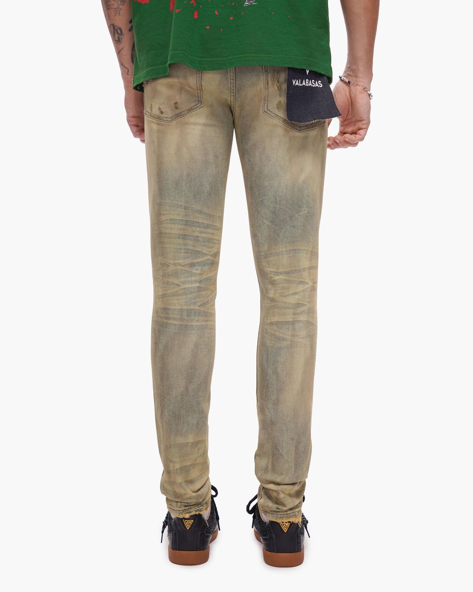 Person wearing beige distressed jeans with a visible brand logo on a white background