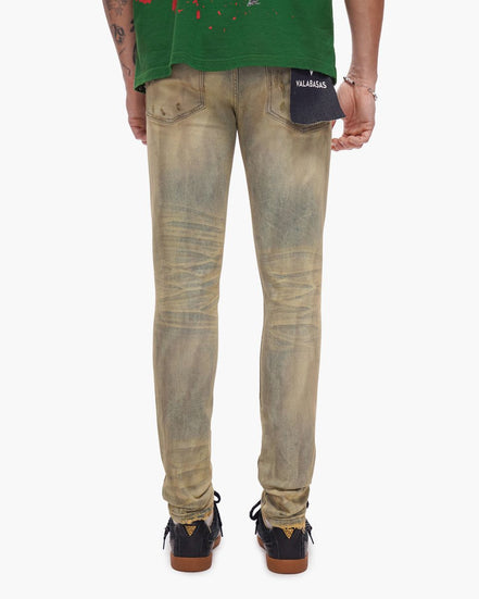 Person wearing beige distressed jeans with a visible brand logo on a white background