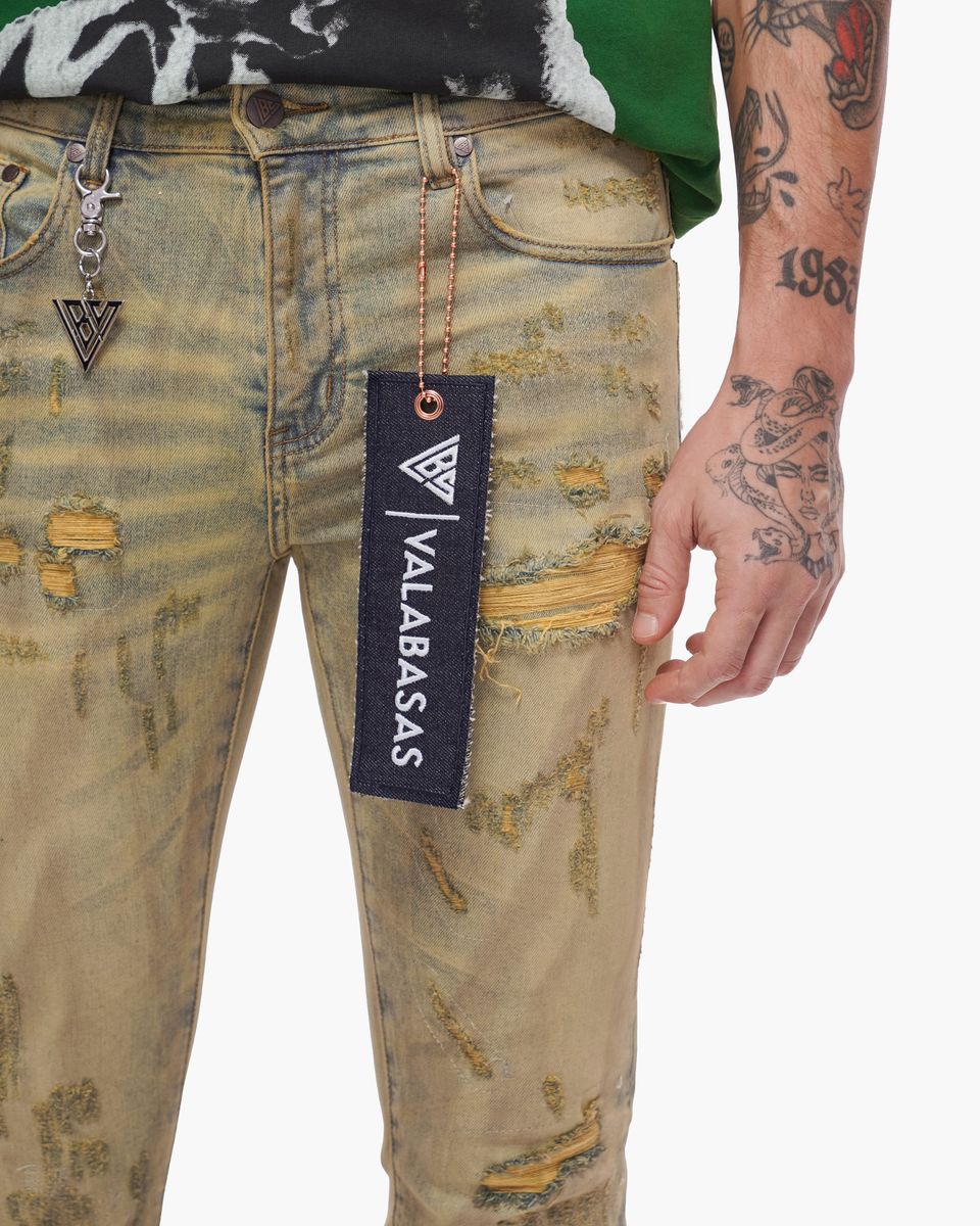 Distressed jeans with a visible brand tag on a white background