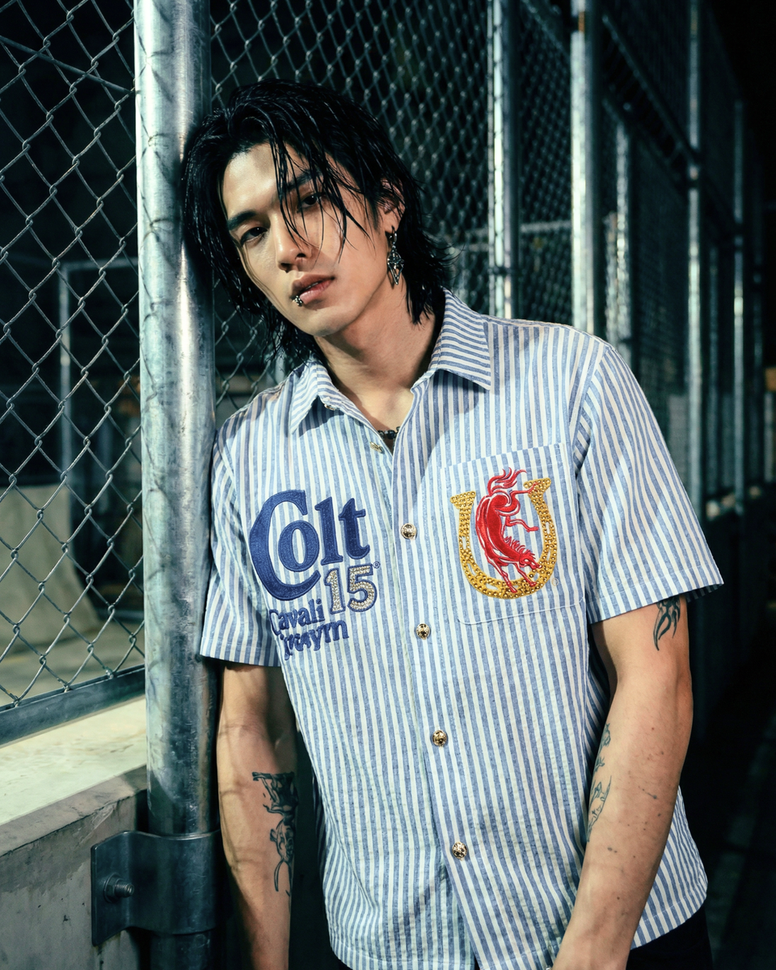 Person wearing a striped shirt with brand logos in an outdoor setting