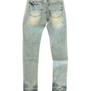 Light wash blue denim jeans shown from the back, featuring a faded yellowish tint on the thighs and a dark blue tie-dye pattern at the hem.