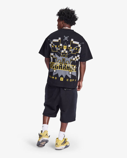 Person wearing a black t-shirt with graphic design and text, standing on a white background