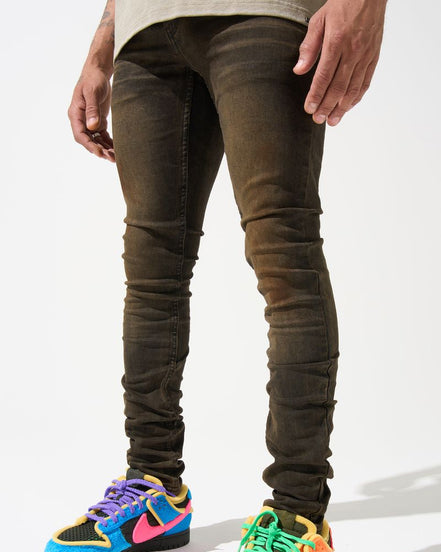 Person wearing dark jeans and colorful sneakers on a white background
